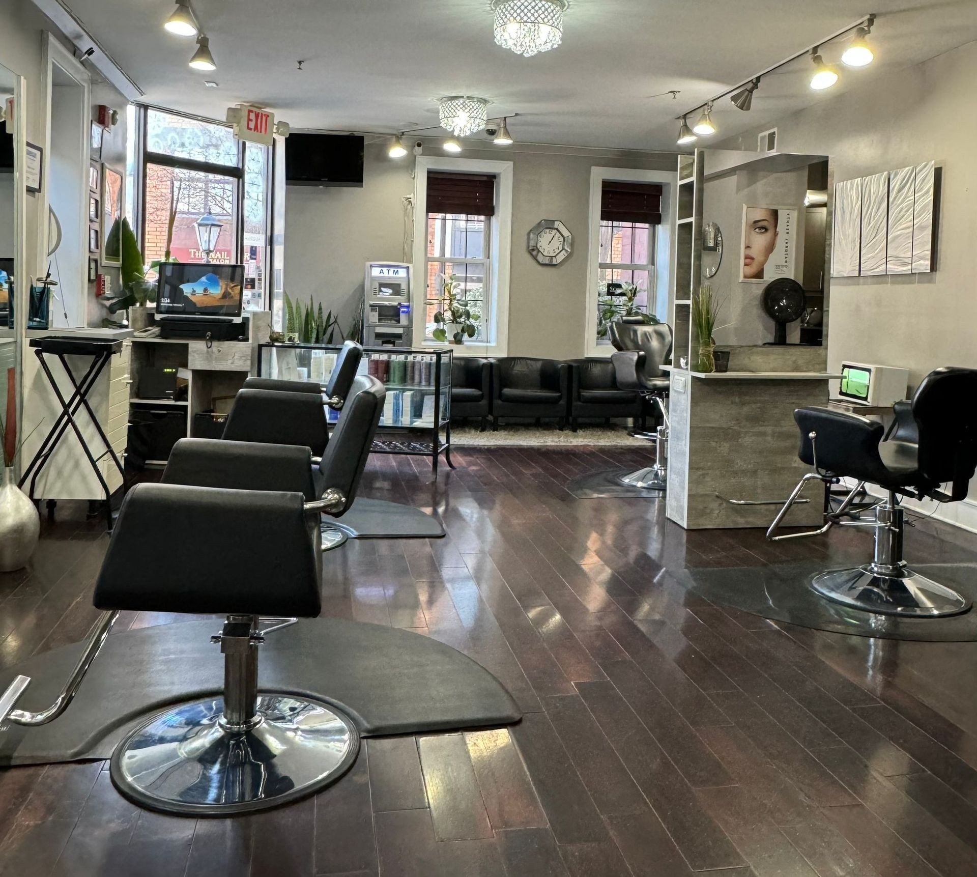 Modern hair salon interior with styling chairs, mirrors, and decorative plants.